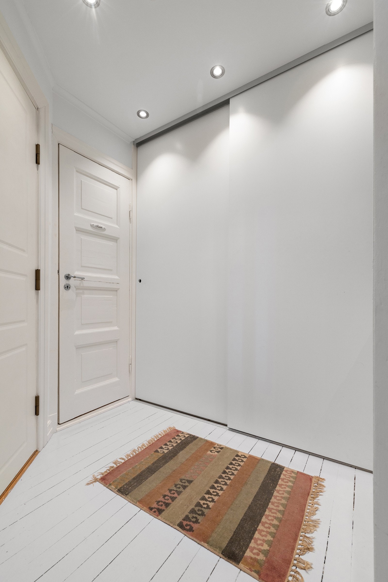 Leiligheten har en romslig og innbydende entré med god plass til oppbevaring av sko og yttertøy i garderobeskap Galleribilde