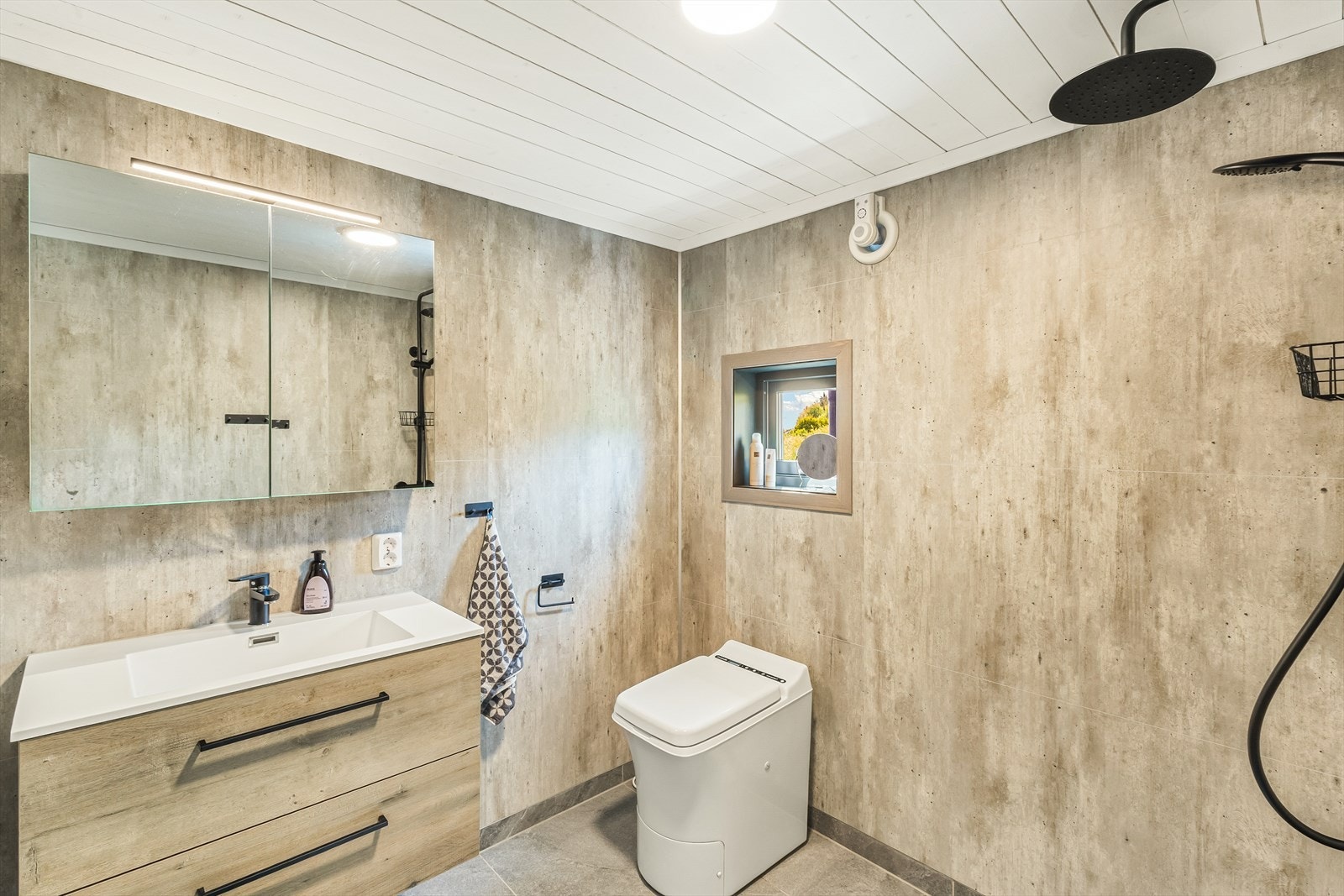 Badet er innredet med baderomsinnredning med servant, forbrenningstoalett og dusj. Galleribilde