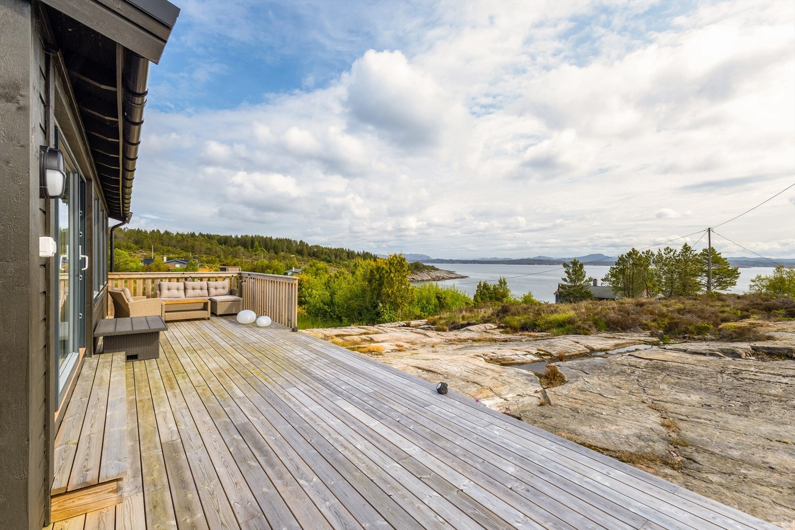 Naturtomt med stor terrasse rundt hytten. Galleribilde