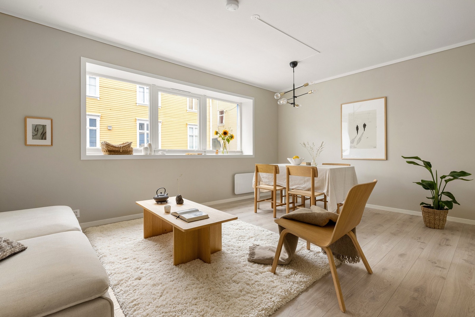 Planløsningen på rommet gjør det enkelt å møblere med både sofagruppe i den ene enden, og spisebord i den andre. Galleribilde