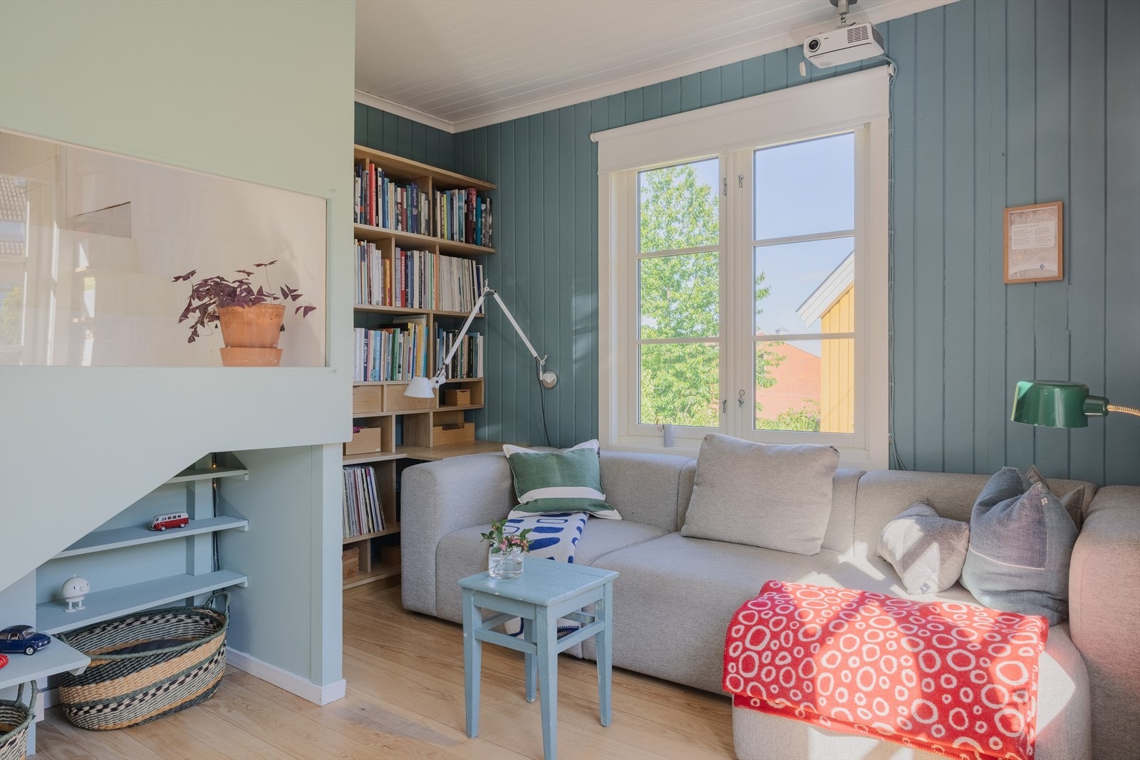 Et koselig allrom med plass til sofa og en spesialdesignet hylleløsning i eikefiner som gir både karakter og praktisk oppbevaring. Galleribilde