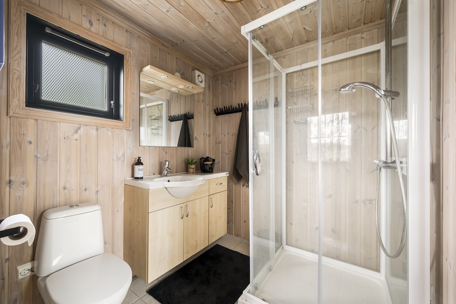 Pent bad med baderomsinnredning, toalett og dusjkabinett. Fliselagt gulv med varmekabler. Galleribilde