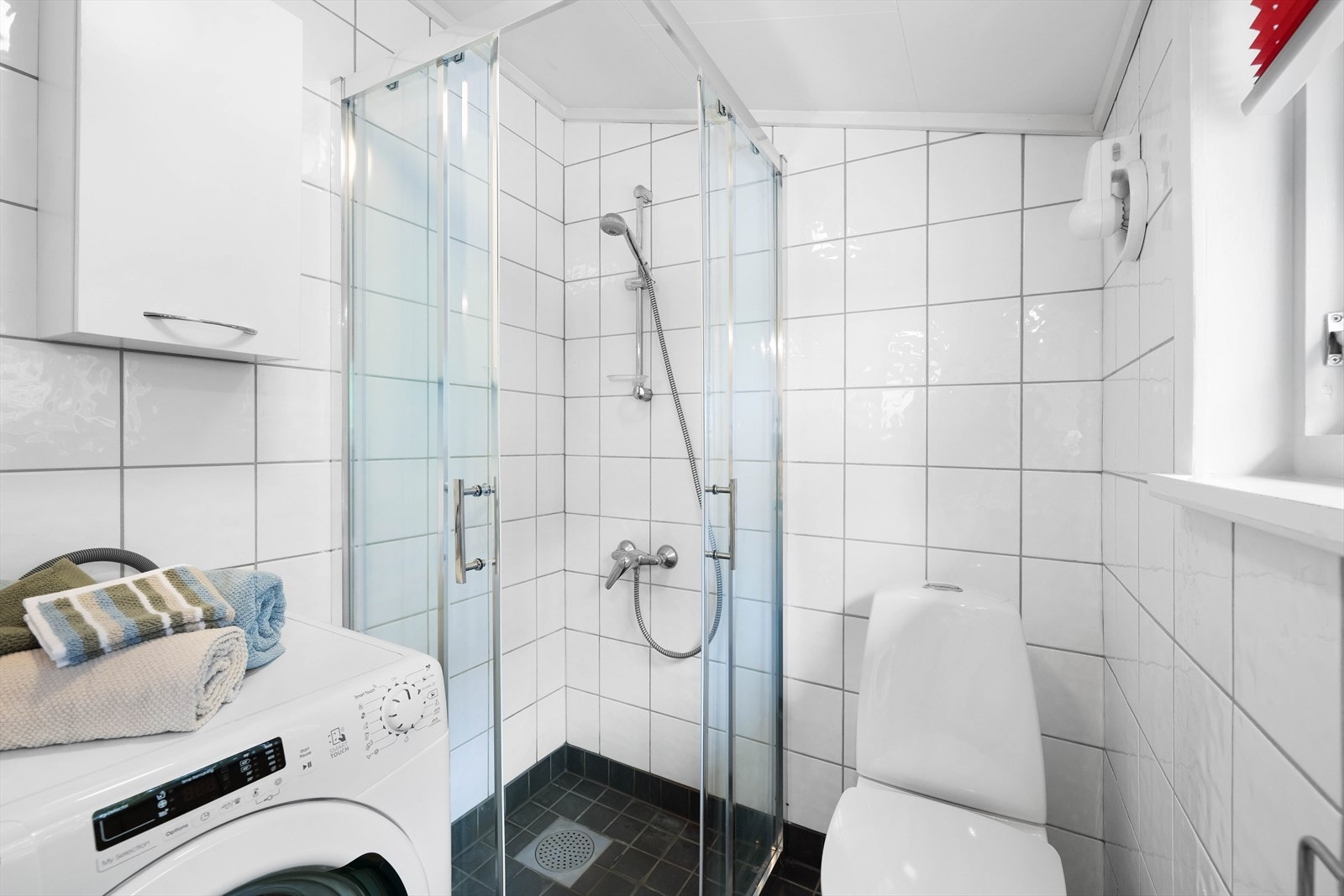 Badet er flislagt og har plass til vaskemaskin. Galleribilde