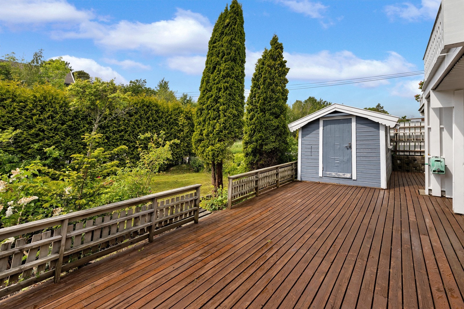Stor solrik terrasse med tilhørende grønn hage Galleribilde