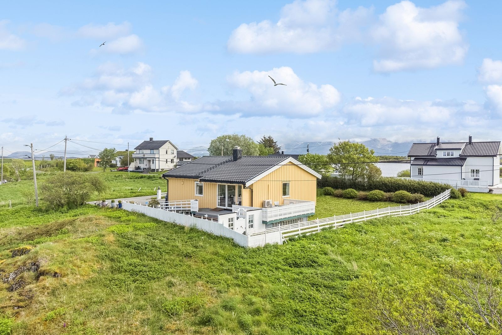 Terrassen er vendt mot sør og vest. Adkomst til hagen via hvit port nedenfor terrassen. Galleribilde