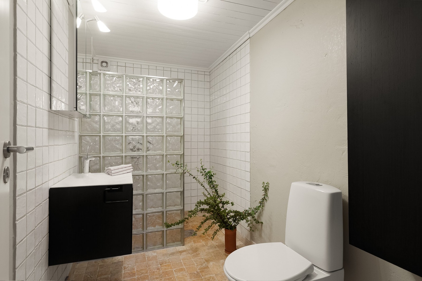 Bad i kjelleren med marmorflis og varmekabler på gulv og stor dushsone. Galleribilde