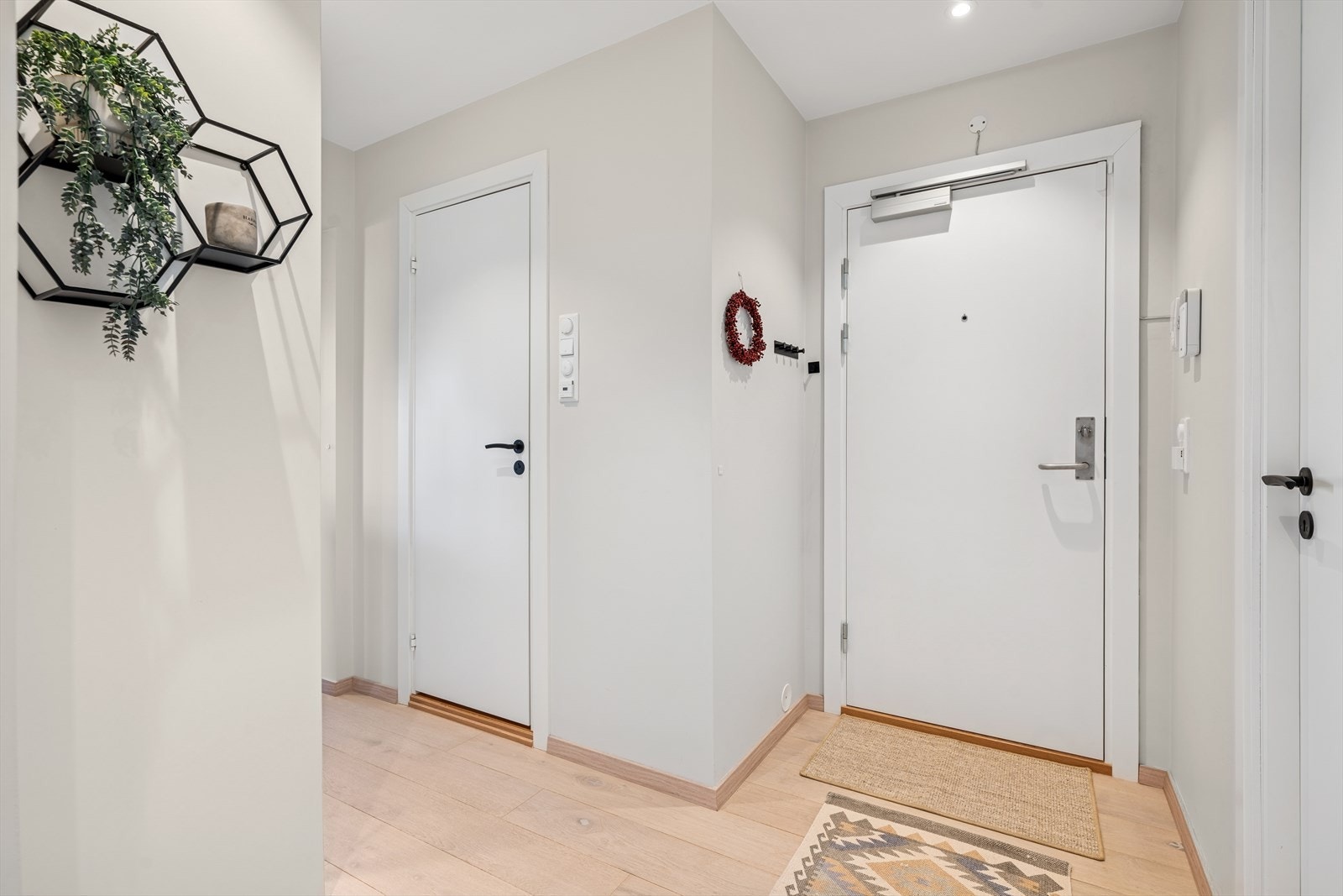 Fra gangen kommer man seg inn til blant annet badet, videre inn til kjøkkenet, samt begge soverommene og stuen Galleribilde