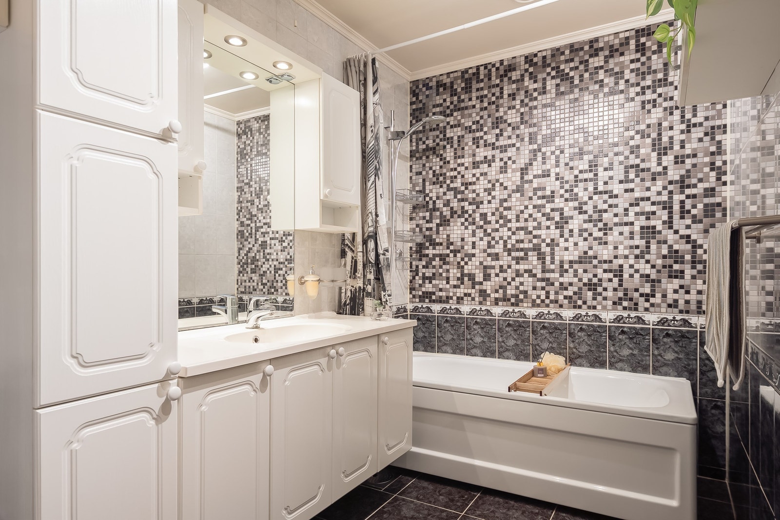 Badet er på 5,5 kvm., har stor innredning med mye skapplass, badekar og toalett. Flislagt på vegger og gulv, med gulvvarme. Galleribilde