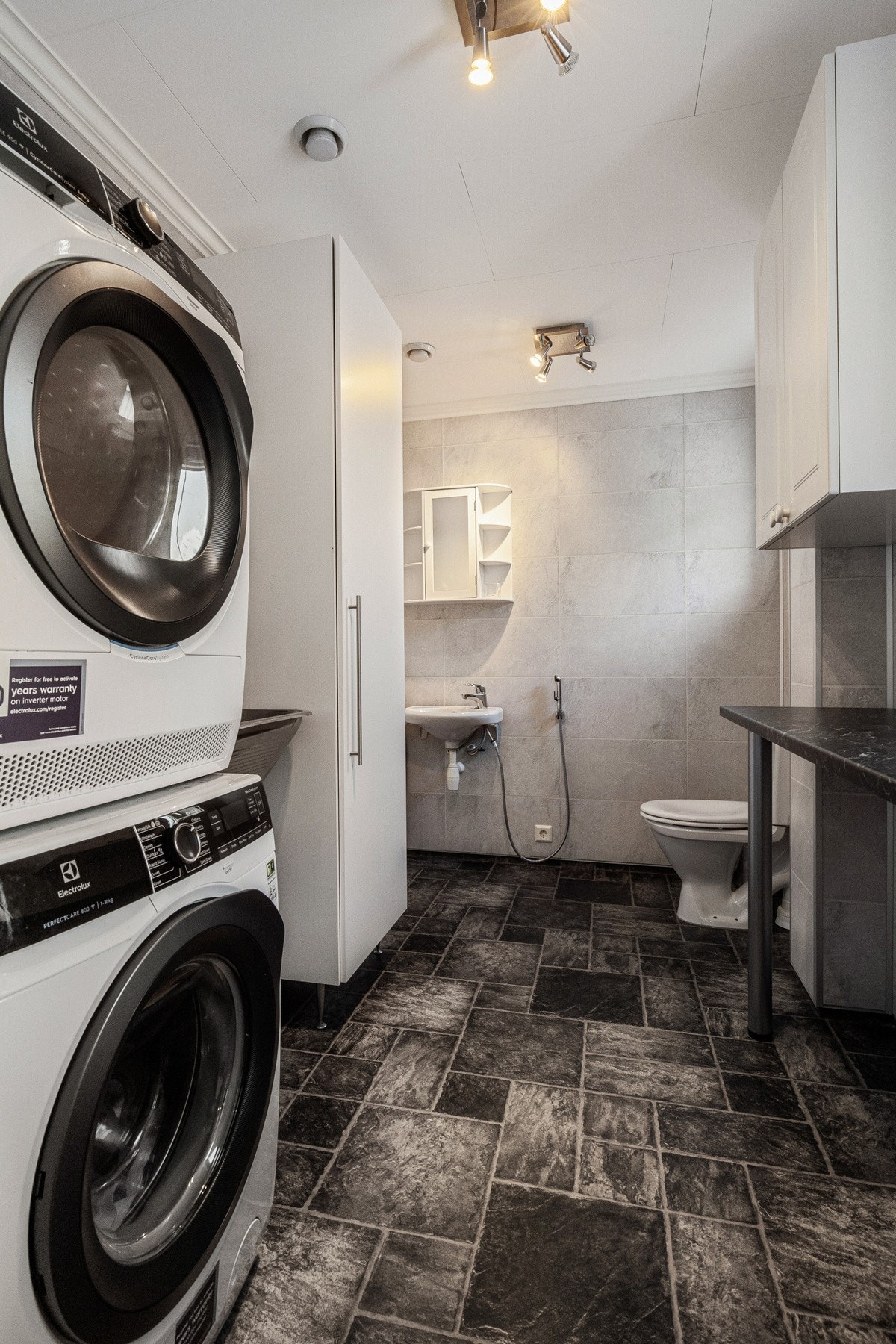 Vaskerommet er av god størrelse med opplegg for både vaskemaskin og tørketrommel, gode oppbevaringsmuligheter, toalett og vask Galleribilde