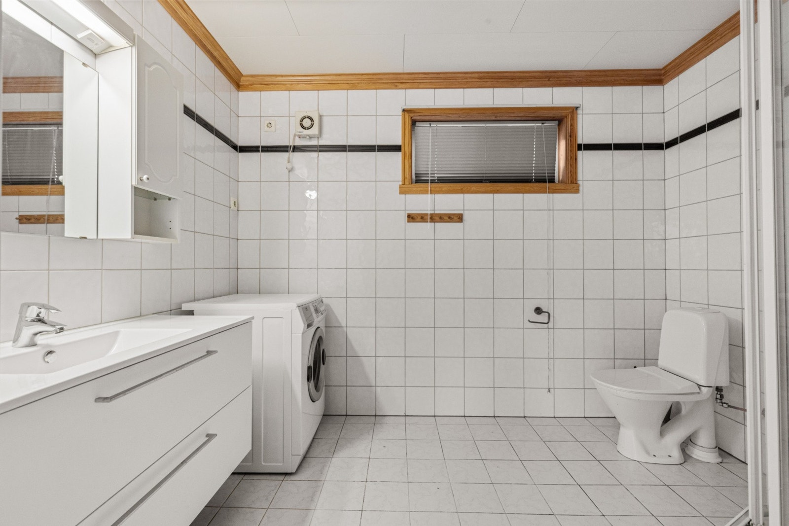 Baderommet er av god størrelse og er bestående av servant med underskuffer, toalett, dusjkabinett og opplegg for vaskemaskin Galleribilde