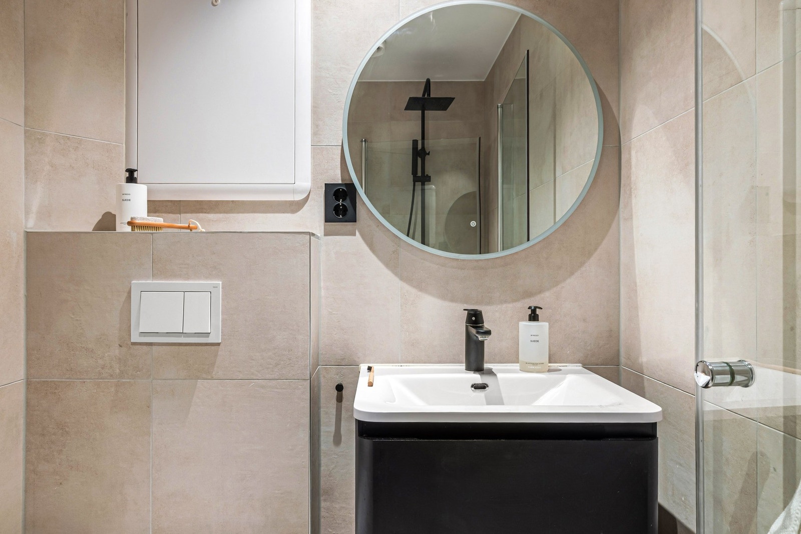 Badet er innredet med dusj med glassvegger, vegghengt toalett,
skapinnredning og opplegg for vaskemaskin. Galleribilde