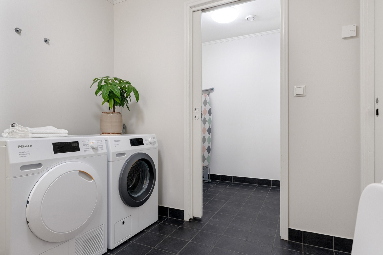 I bakkant av badet, befinner det seg et praktisk tørkerom/teknisk rom. Der er det blant annet montert et skap for sortering av ulike klesplagg. Galleribilde