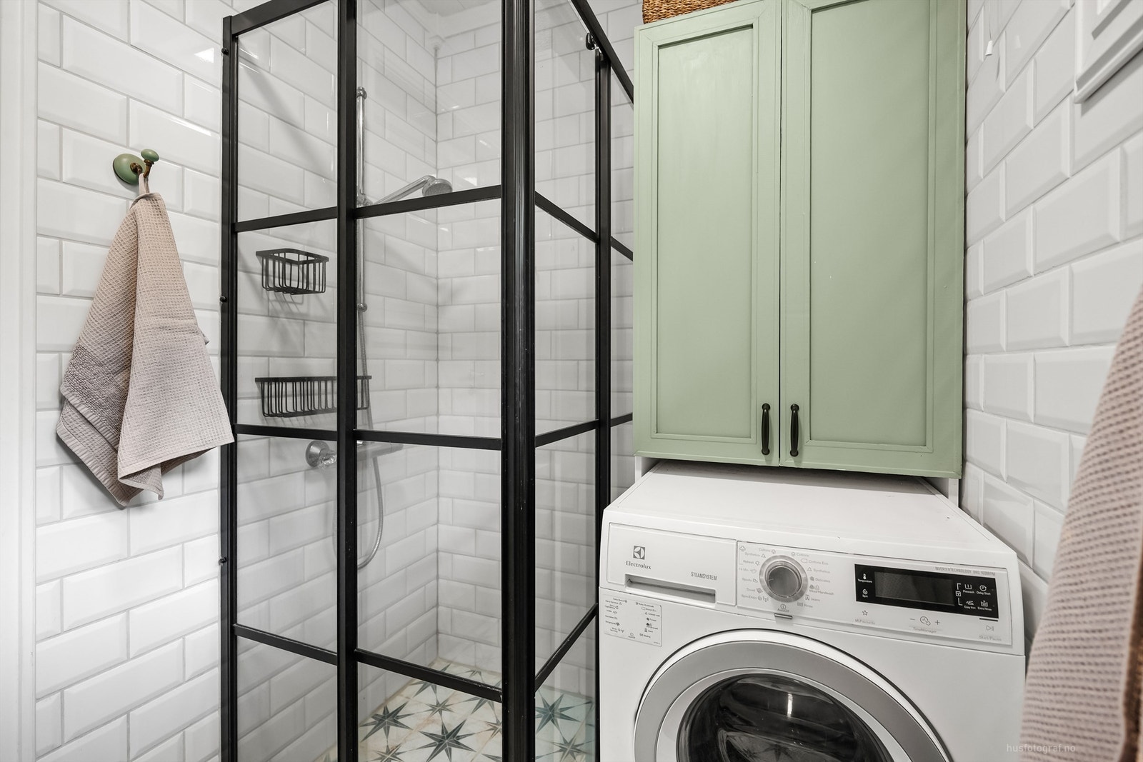 Dusjhjørne med i glass og vaskemaskin med plassbygget overskap Galleribilde