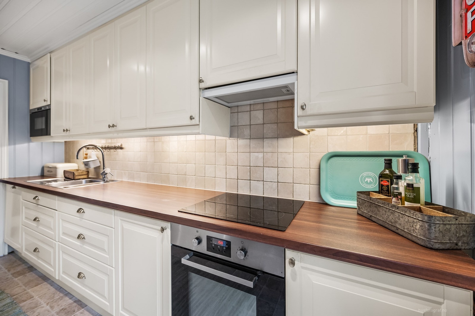 Stilrent kjøkken med godt utnyttet skap- og benkplass Galleribilde