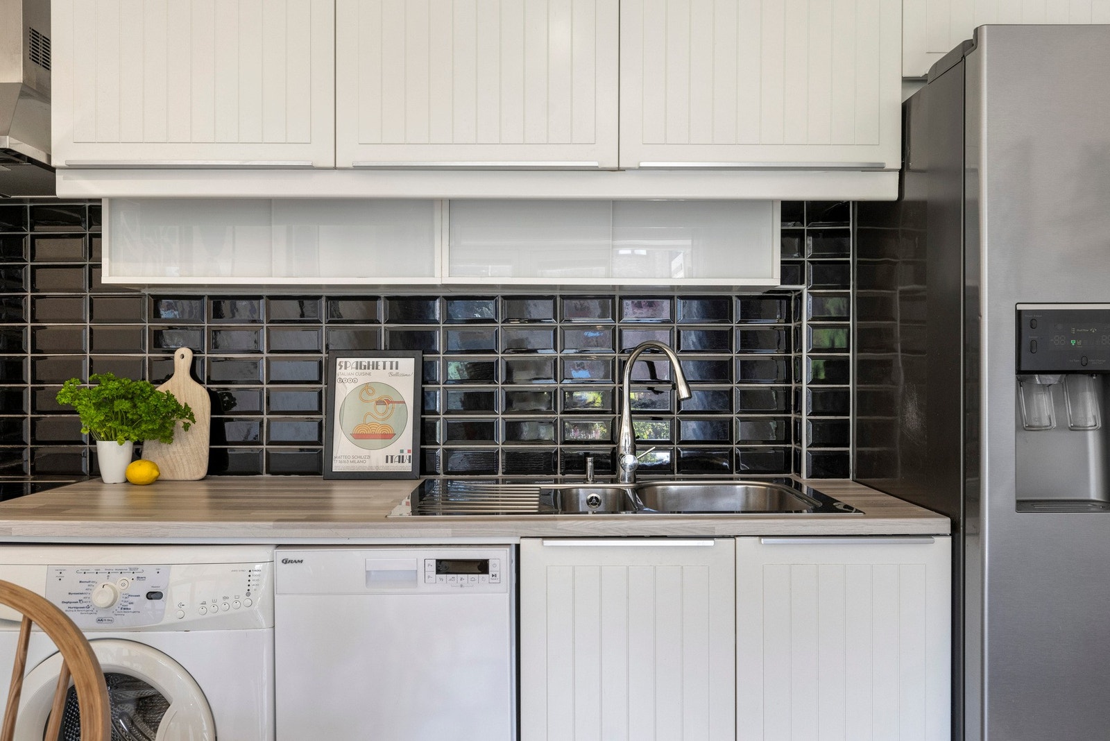 - Pent kjøkken med profilerte fronter. Benkeplate i laminat. Flislagt vegg over kjøkkenbenk - Galleribilde