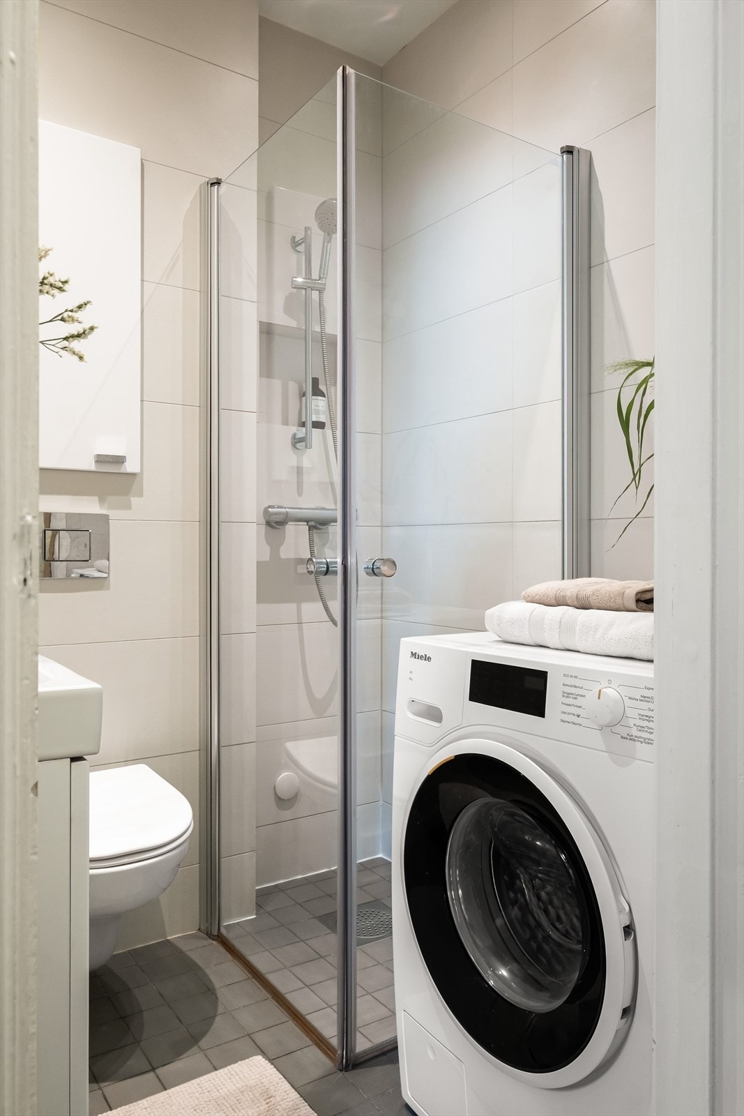 Baderommet er innredet med vegghengt klosett, servant med innredning og dusjhjørne med svingbare glassdører. Opplegg for vaskemaskin. Galleribilde