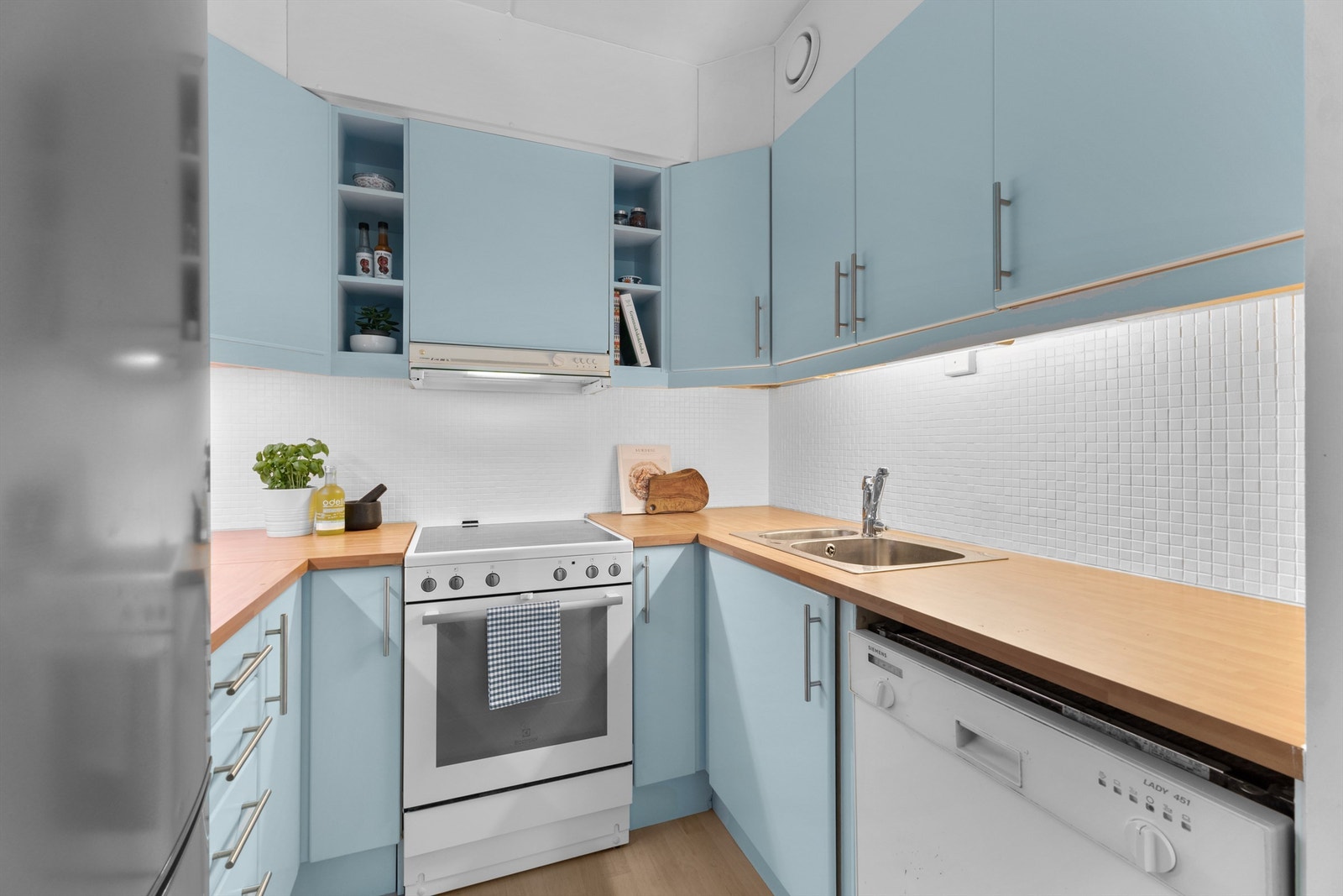 Varmtvannsbereder på 116 liter fra 2002 og brannslange plassert under kjøkkenbenk. Galleribilde