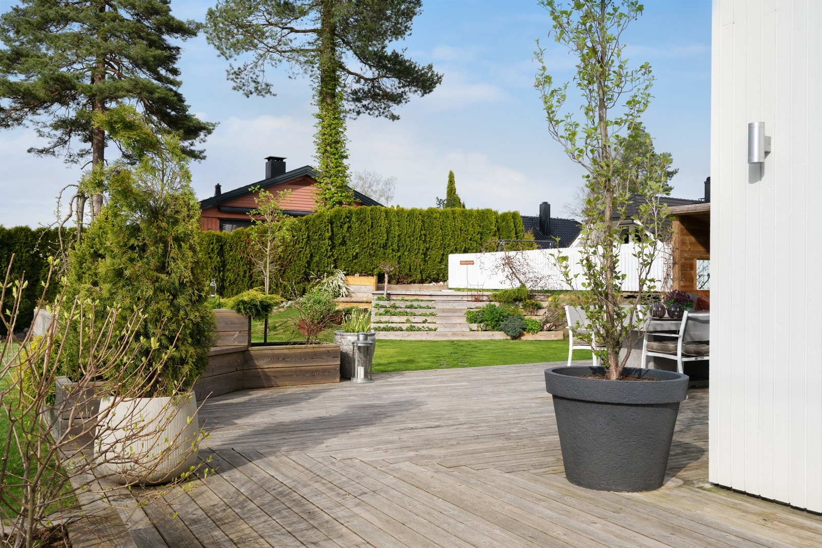 Nede på bakkeplan er det terrasse på hele 81 kvm, og stor hage avgrenset med gjerde og hekk mot naboer. Galleribilde