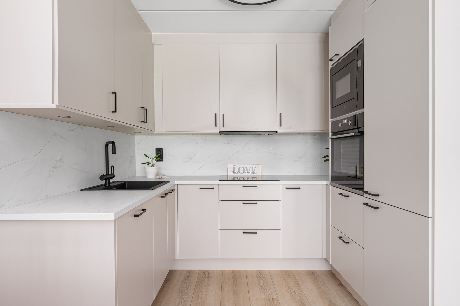 Integrerte hvitevarer medfølger handelen. Kjøkkenet er utstyrt med kjøleskap, stekeovn, mikrobølgeovn og oppvaskmaskin. Galleribilde