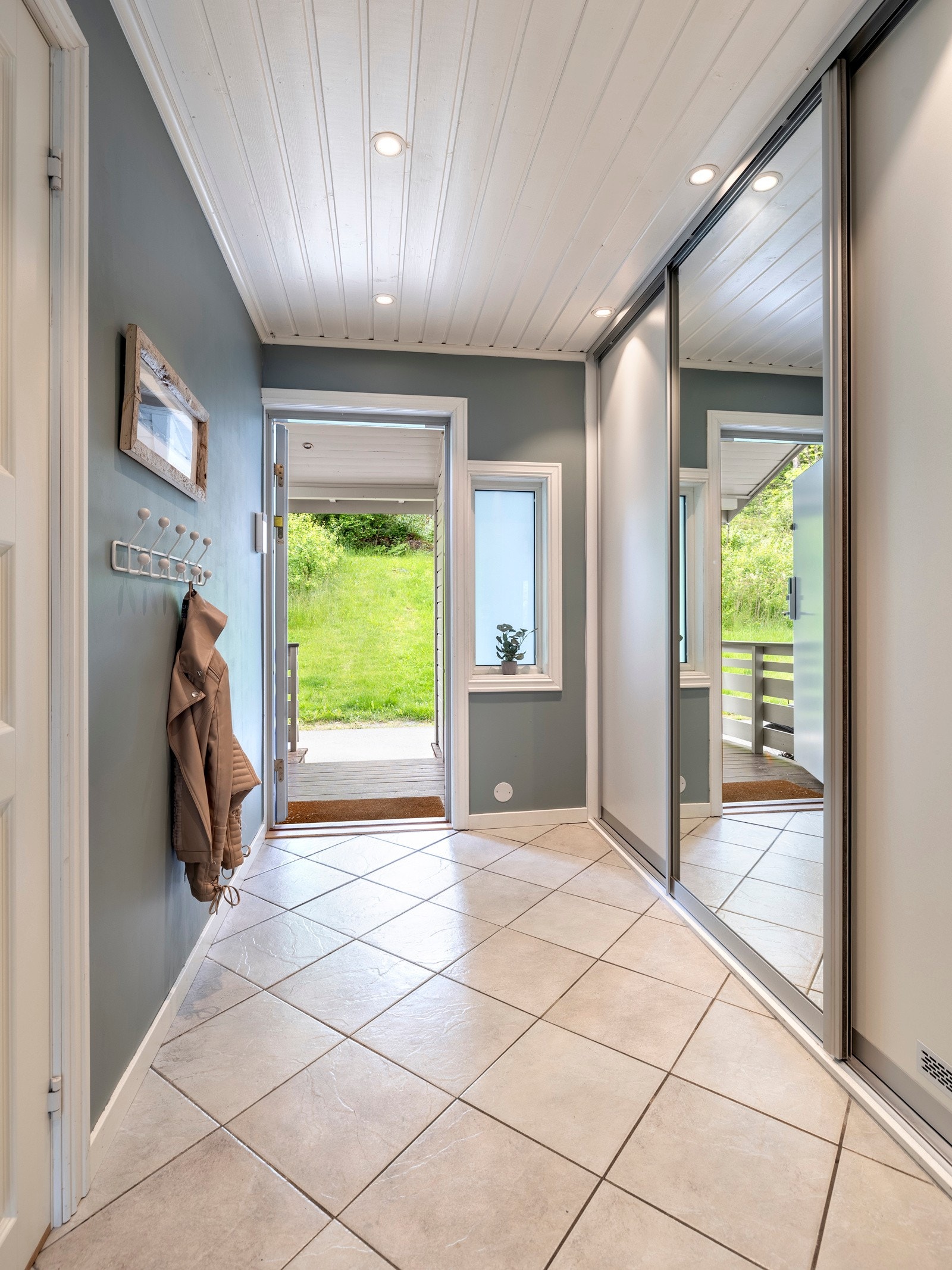 Entreen er innredet med en skyvedørsgarderobe som har speilfronter, i tillegg til praktisk bod med god lagringsplass. Galleribilde