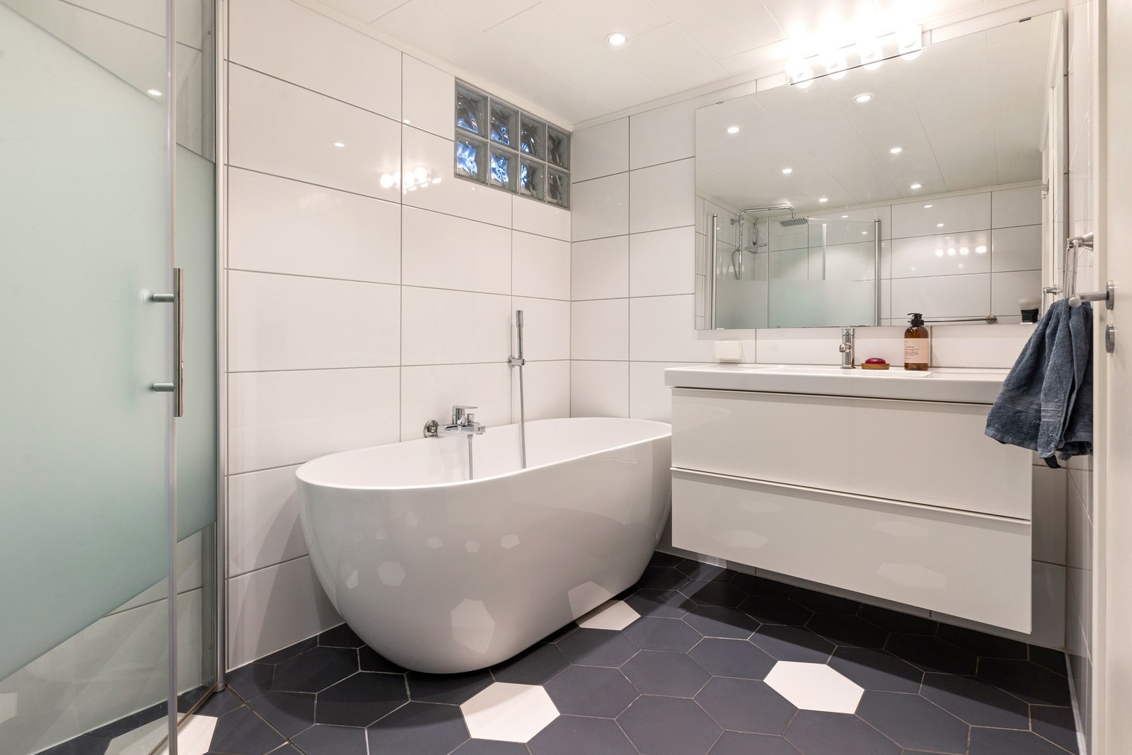 Baderomsinnredningen er med nedfelt servant, gulvfestet toalett, dusjhjørne og badekar Galleribilde