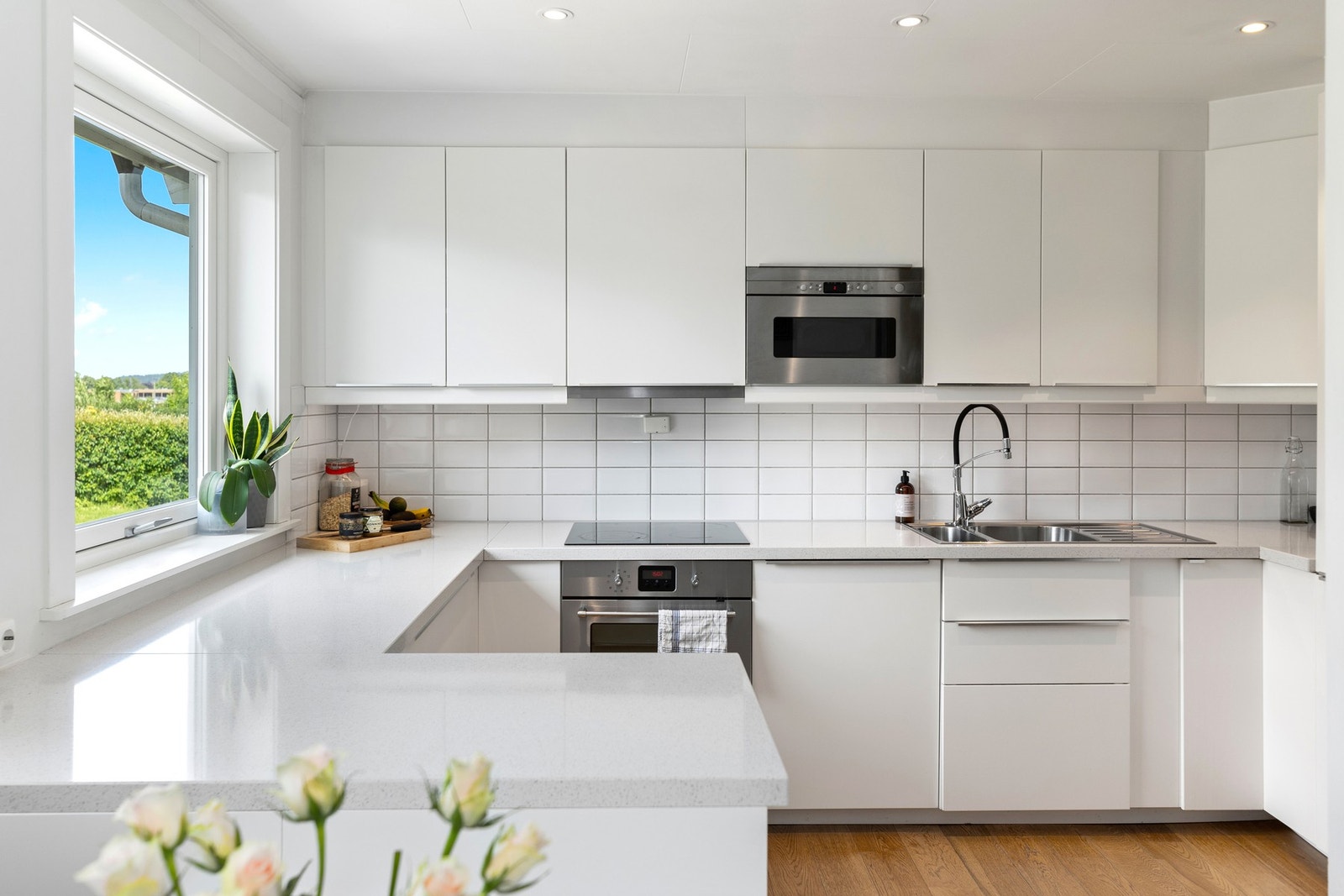 Kjøkkenet er praktisk og stilrent utstyrt med slette fronter, eksklusiv benkeplate av stein og integrerte hvitevarer som komfyr, platetopp, kjøl/fryseskap, mikrobølgeovn og oppvaskmaskin Galleribilde