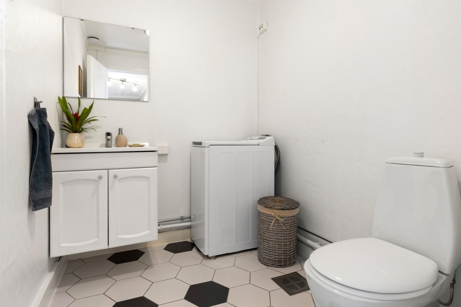 I tillegg har boligen et praktisk vaskerom utstyrt med nedfelt servant, gulvfestet toalett og opplegg for vaskemaskin Galleribilde