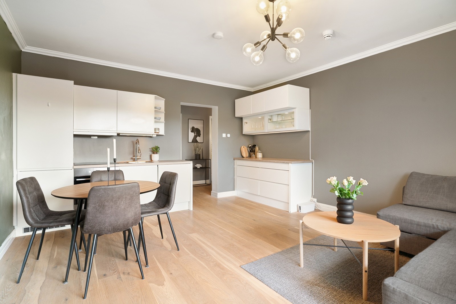 Et sosialt allrom med stilrent kjøkken i åpen løsning. Galleribilde