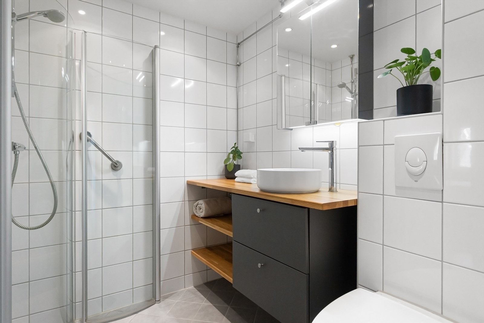 Pent flislagt bad fra 2012 i regi av borettslaget. Badet har varme i gulv, opplegg for vaskemaskin, toalett, speilskap, dusjhjørne og servant med innredning. Galleribilde