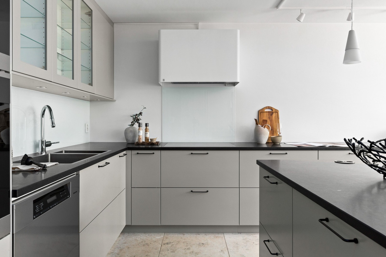 Innredningen er fra Drømmekjøkkenet, med slette, grå fronter som gir et rent og stilfullt uttrykk. Benkeplatene er laget av slitesterk stein. Galleribilde