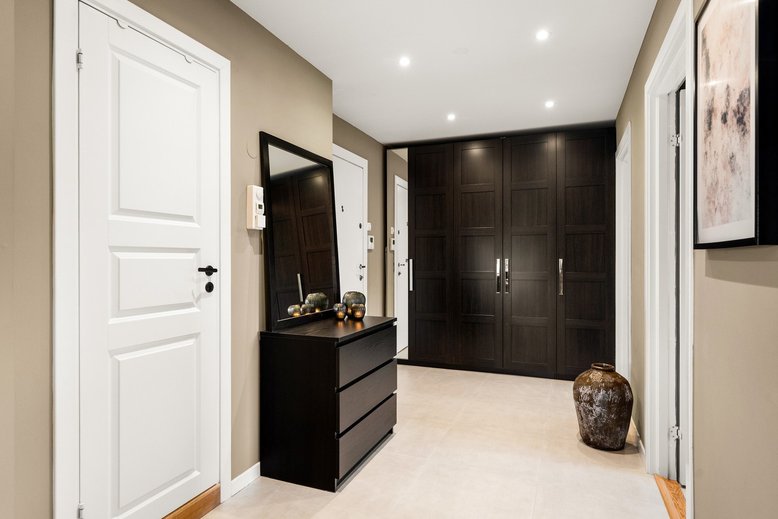 Entréen gir et godt førsteinntrykk av boligen med delikate fargevalg på vegger, fliser på gulv med varmekabler og god plass for oppbevaringsmøblement. Galleribilde