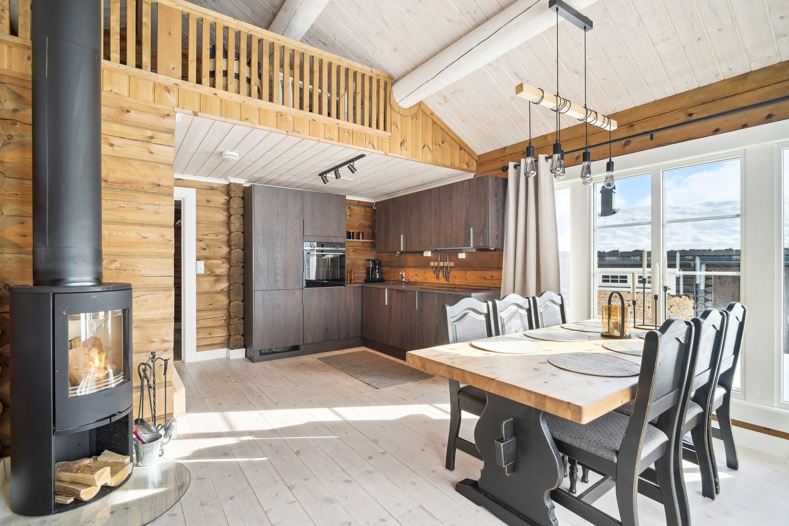 Stor og luftig åpen stue/kjøkken-løsning med svær takhøyde. Galleribilde