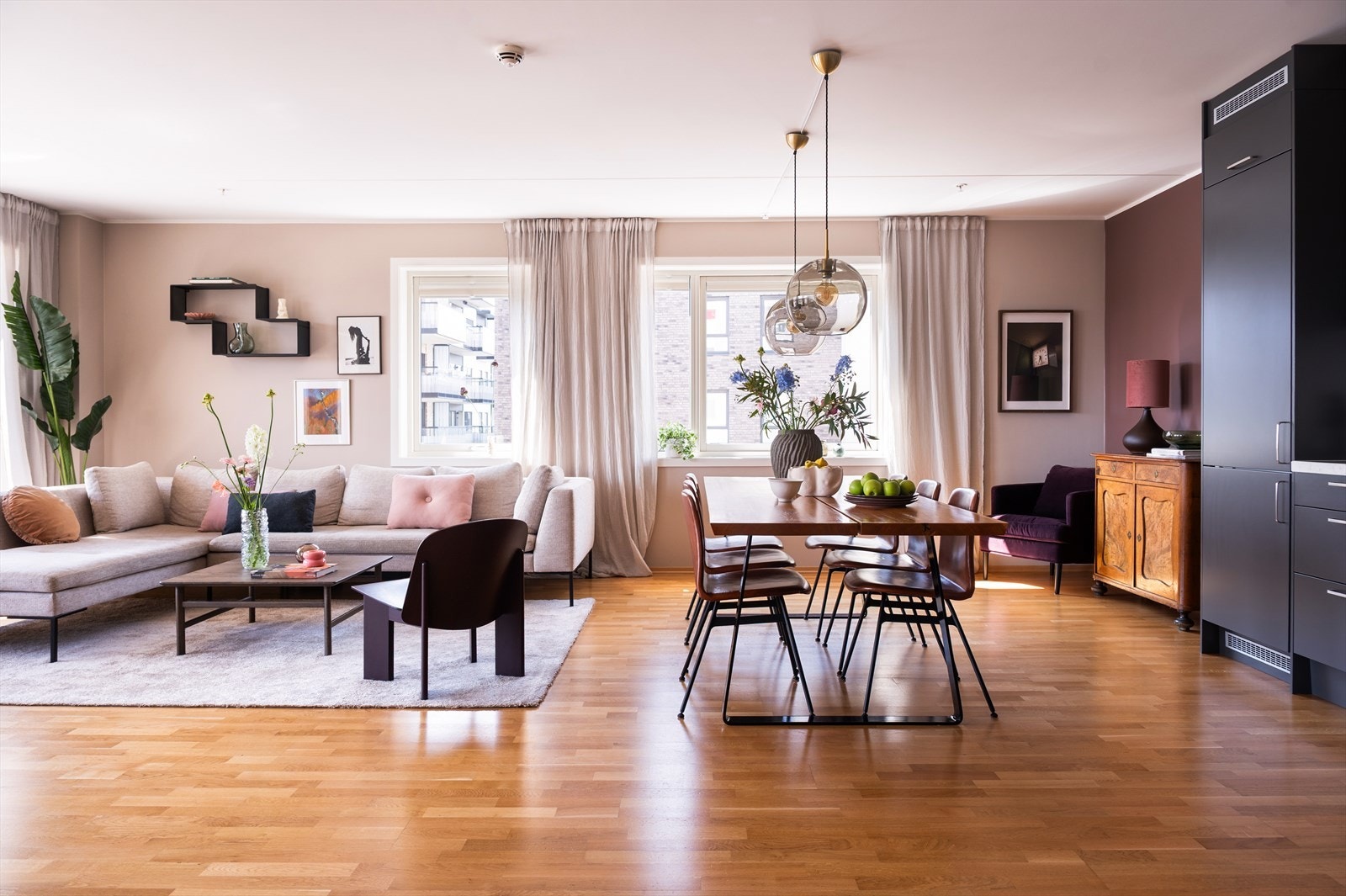 Her finner du en naturlig sone for sofa og salongbord, samtidig som den åpne løsningen mot kjøkkenet gir en sosial og romslig opplevelse. Galleribilde