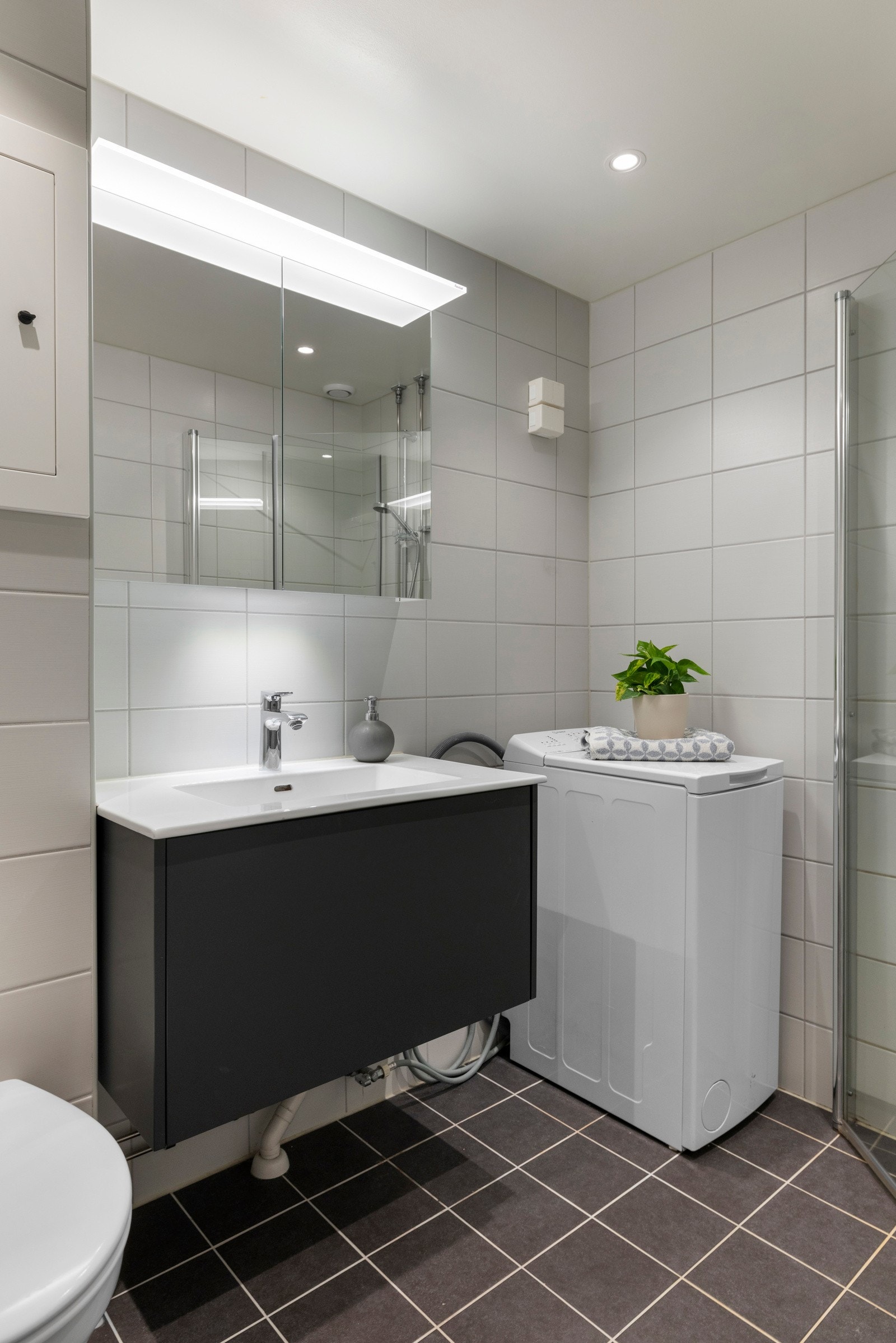 Badet ble pusset opp i 2020 og har flislagt gulv og vegger, samt malt tak med innfelte downlights som gir jevn belysning Galleribilde