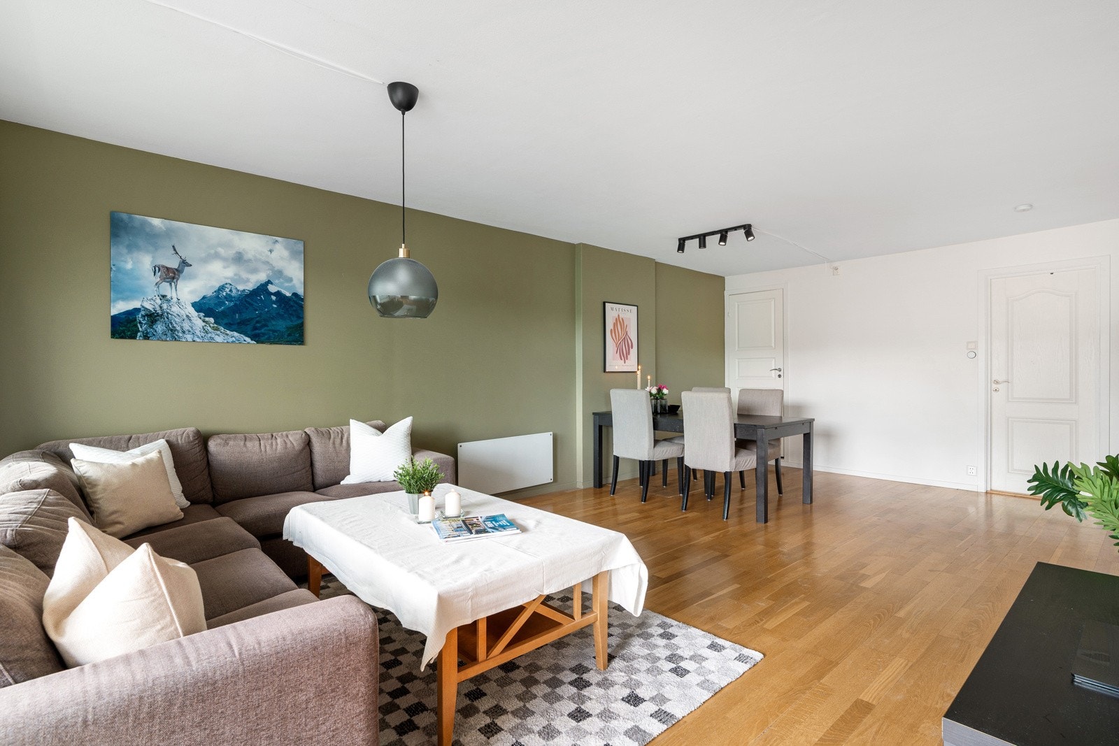Leilighetens stue har god plass til ulike soner for møblering med både spisegruppe, sofa og mediemøblement. Galleribilde