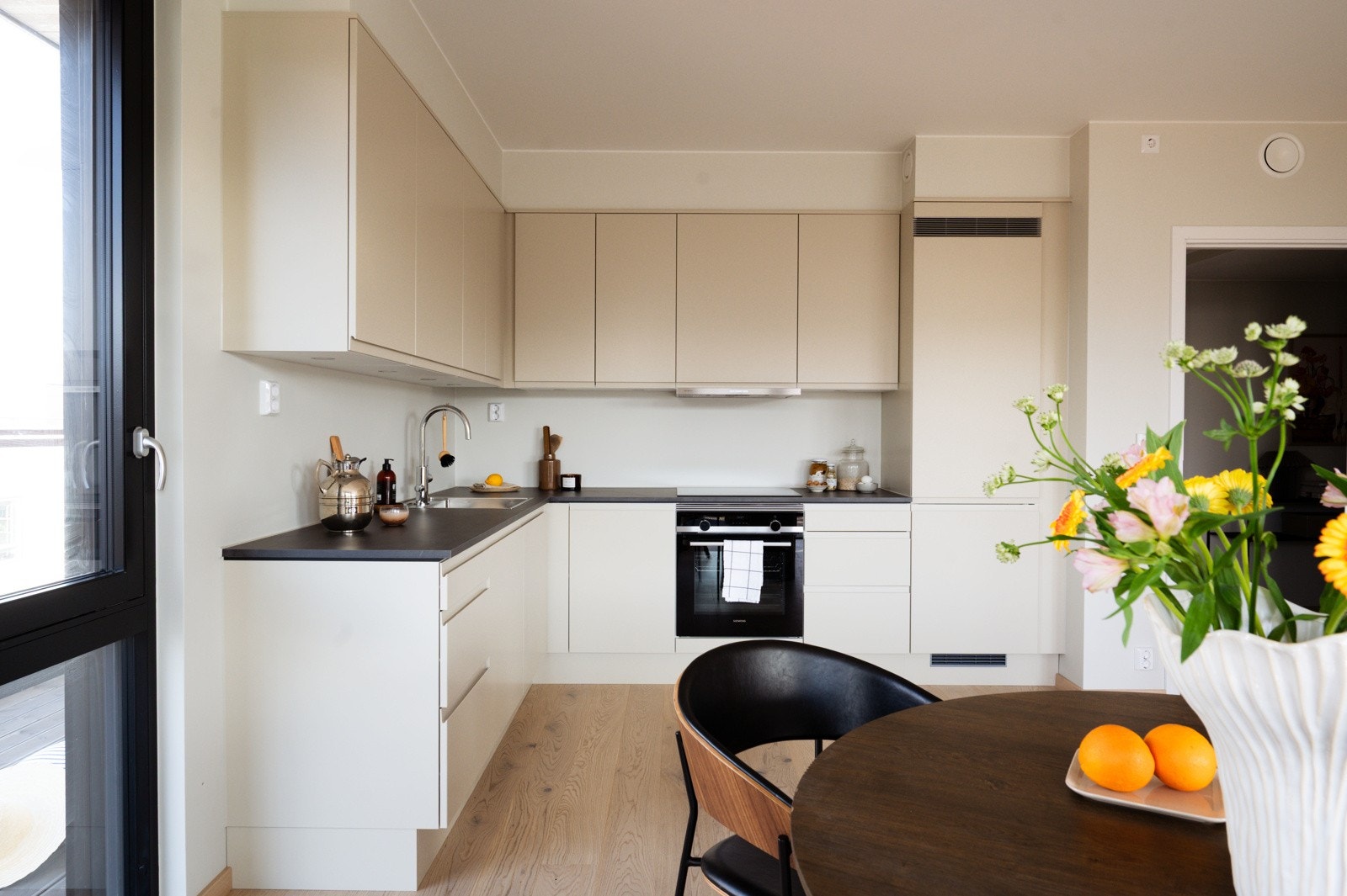 Det moderne Sigdal-kjøkkenet i modellen Horisont kombinerer rene linjer med høy funksjonalitet - med integrerte hvitevarer fra Siemens og en sort laminatbenkeplate med svevekant som gir et eksklusivt og stilrent uttrykk Galleribilde