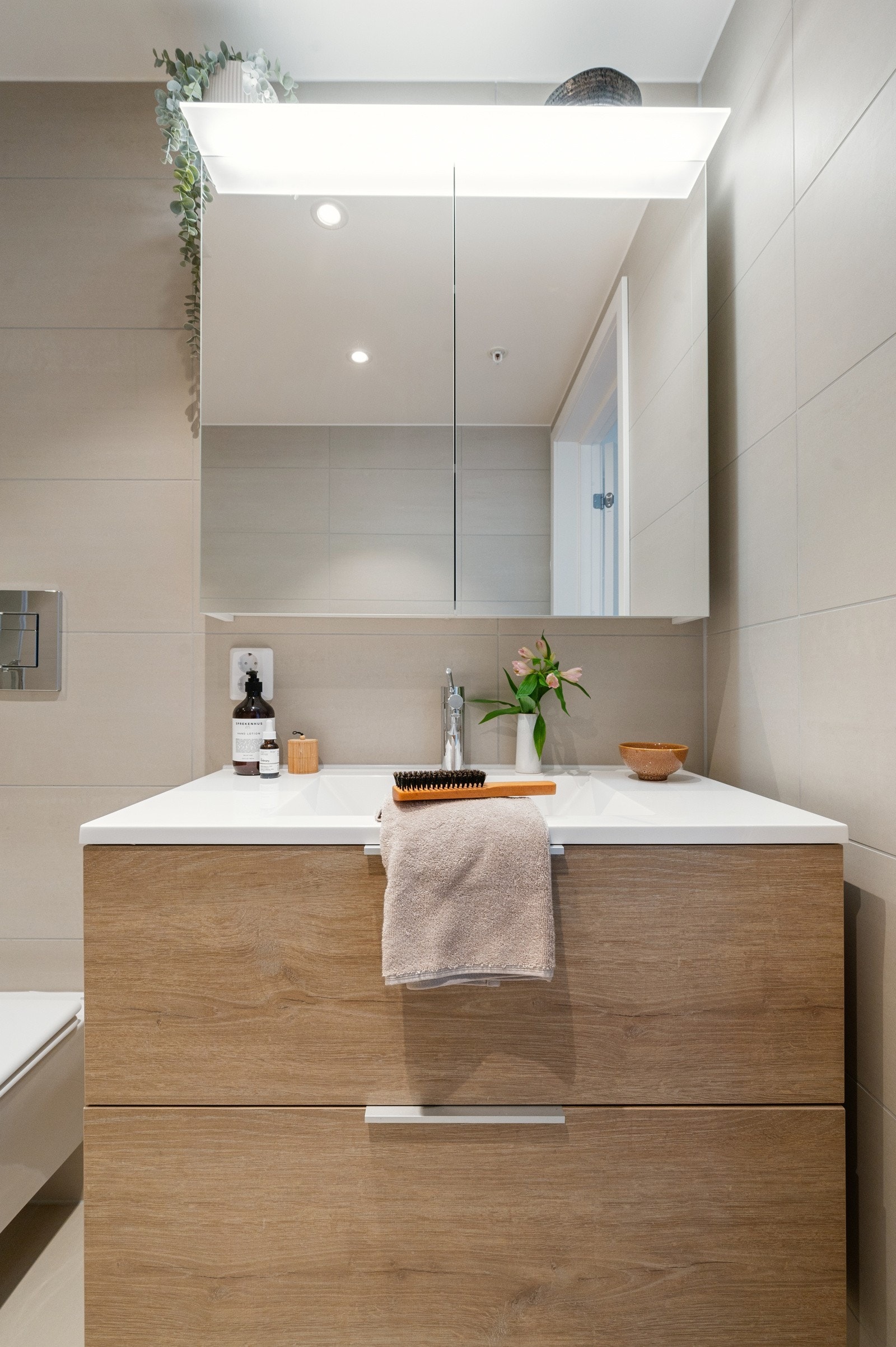 Baderomsinnredningen fra Probad i modellen Eik, kombinert med heldekkende servant og speilskap med integrert lys, gir både funksjon og design i en sømløs løsning Galleribilde