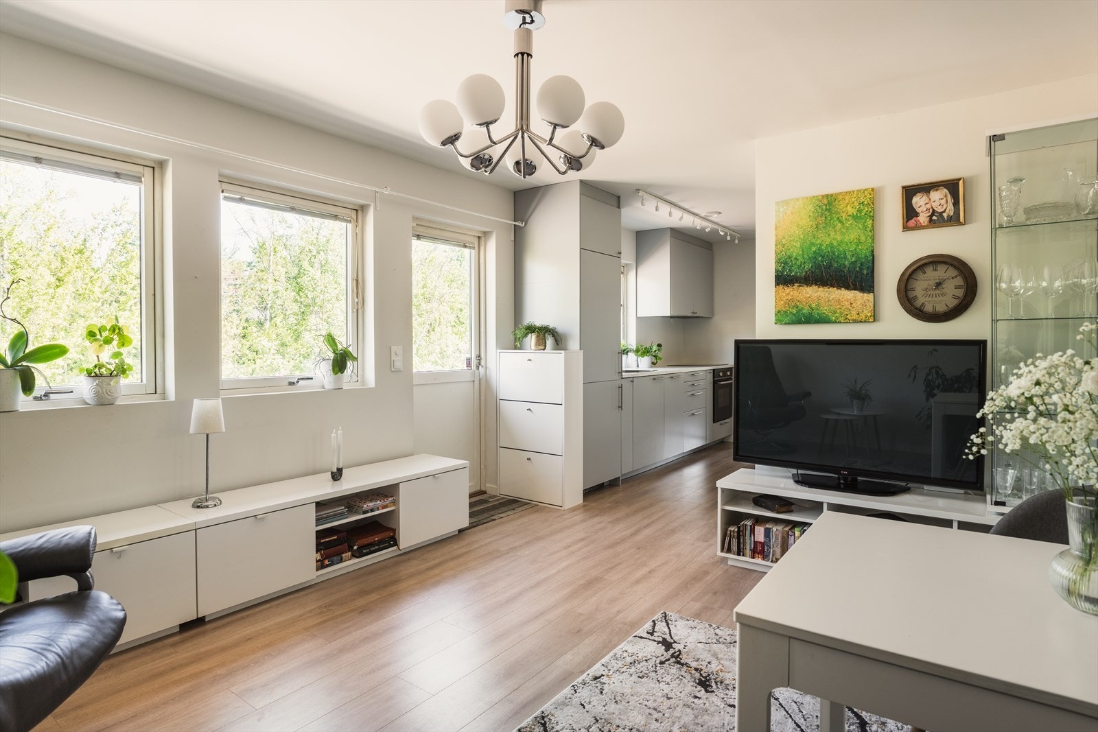Fin størrelse på stuen med plass til både sofagruppe og spisebord. Mange vindusflater slipper inn rikelig med naturlig lys og gir samtidig utsyn til frodige arealer og vannet på Holmendammen. Galleribilde