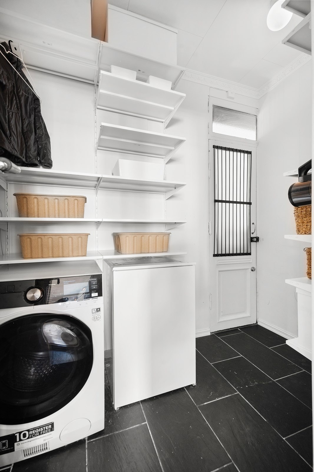 Mellomgang med utgang fra kjøkkenet. Her er det godt med lagringsplass. Opplegg for vaskemaskin og fryser. Galleribilde