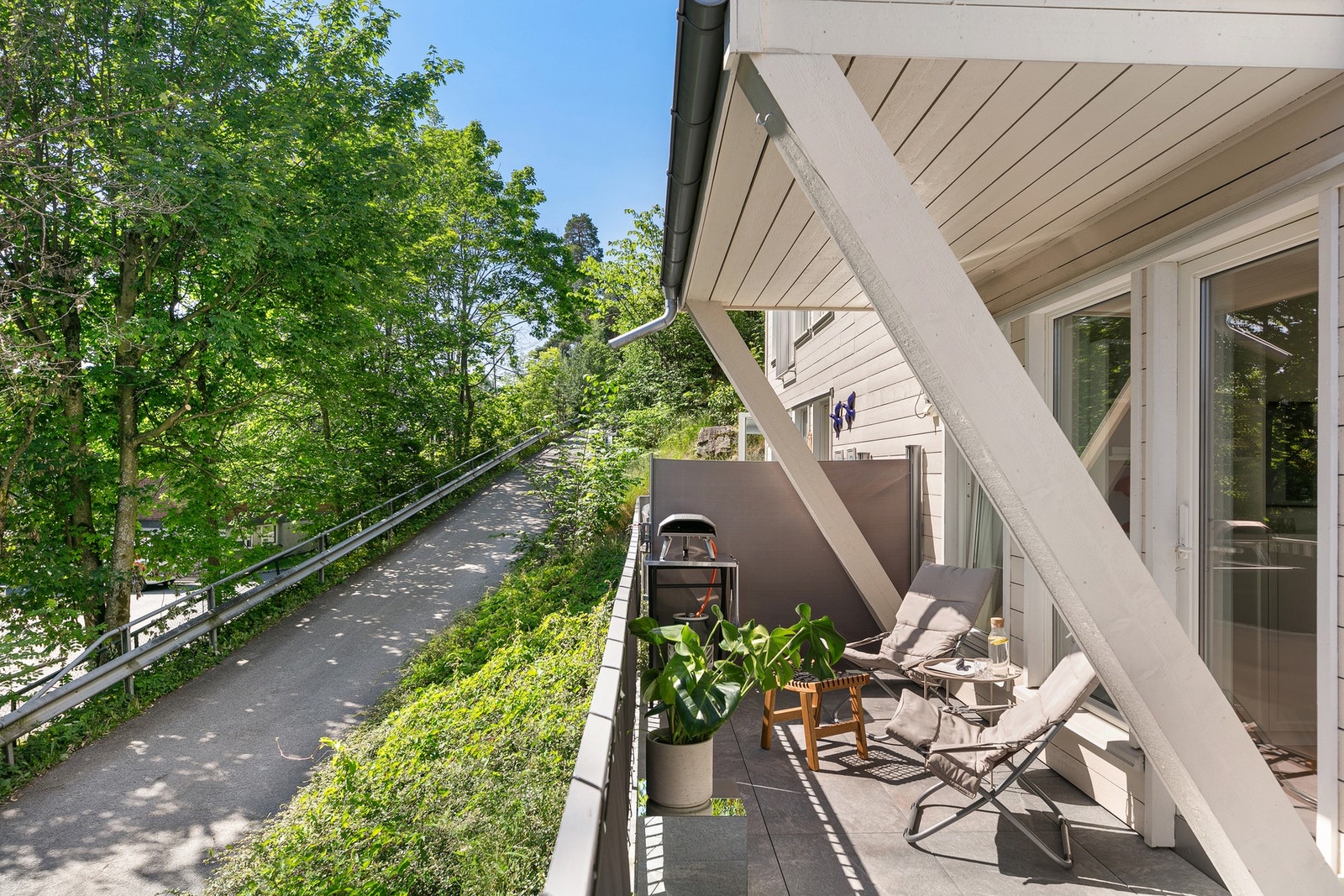 Terrassen har rekkverk i metall og bruksunderlag med steinheller. Galleribilde