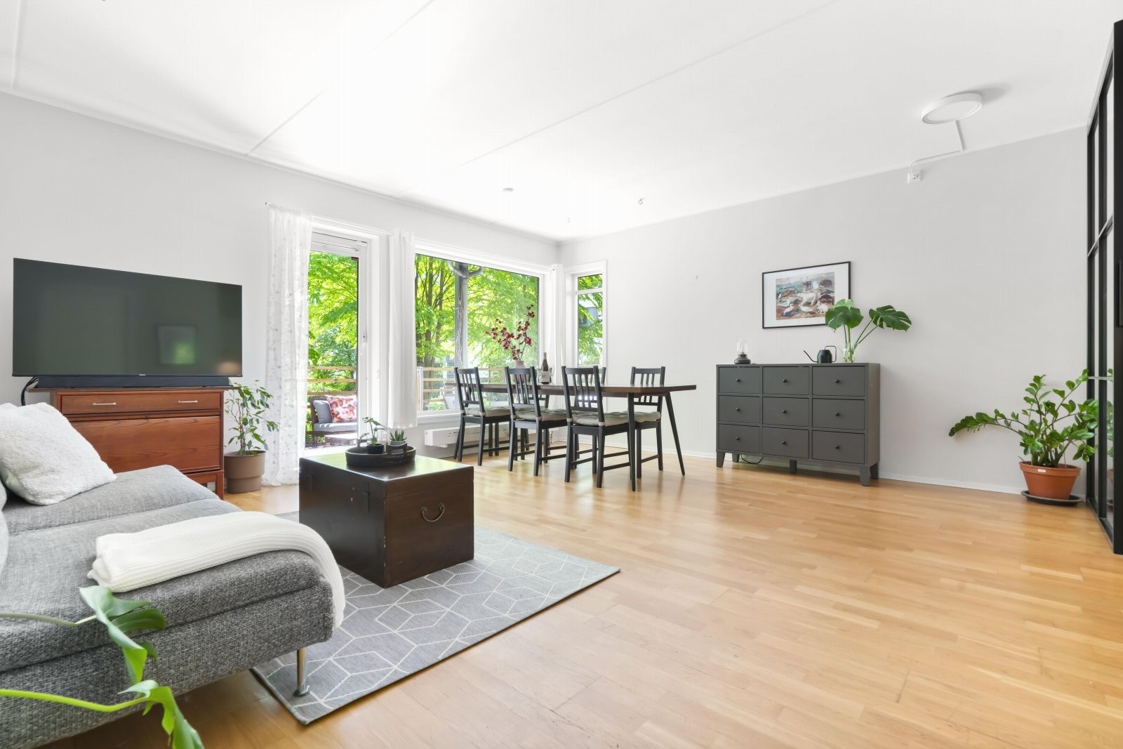 Lys, luftig og åpen stue- og kjøkkenløsning med nydelig, grønt utsyn mot eget uteområdet. Galleribilde