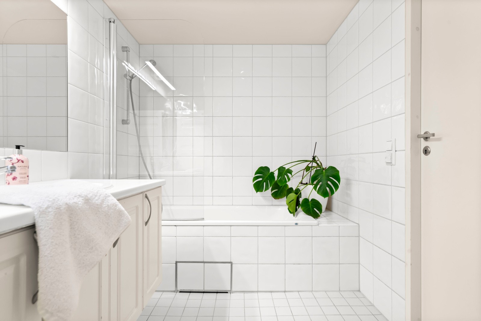 Videre er det innfliset badekar med dusjhodet og toalett. Galleribilde