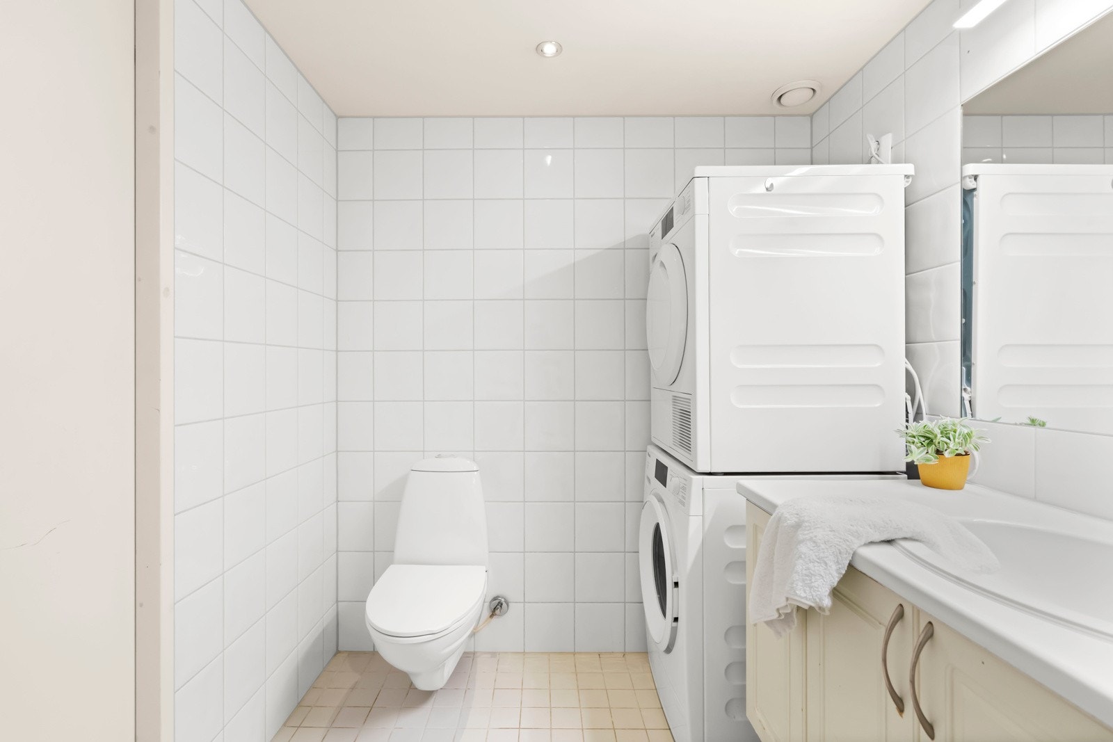 Badet byr på servantskap med glatte, folierte fronter og laminat benkeplate med nedfelt servant. Speilskap med lysarmatur på vegg over servant. Galleribilde