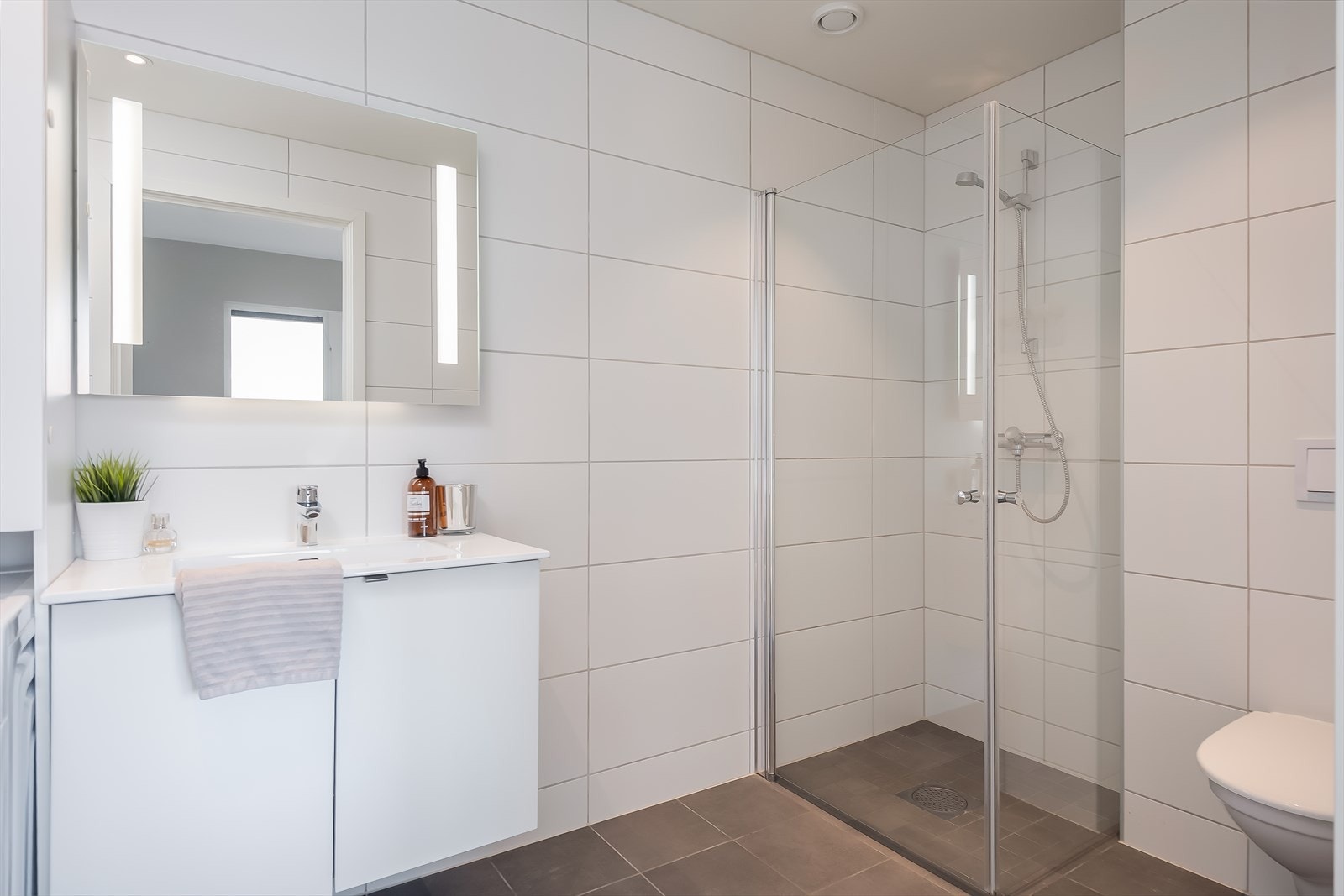 Her får du i tillegg stilrene dusjdører i glass og vegghengt toalett. Badet er vurdert til TG0 av takstmann. Galleribilde