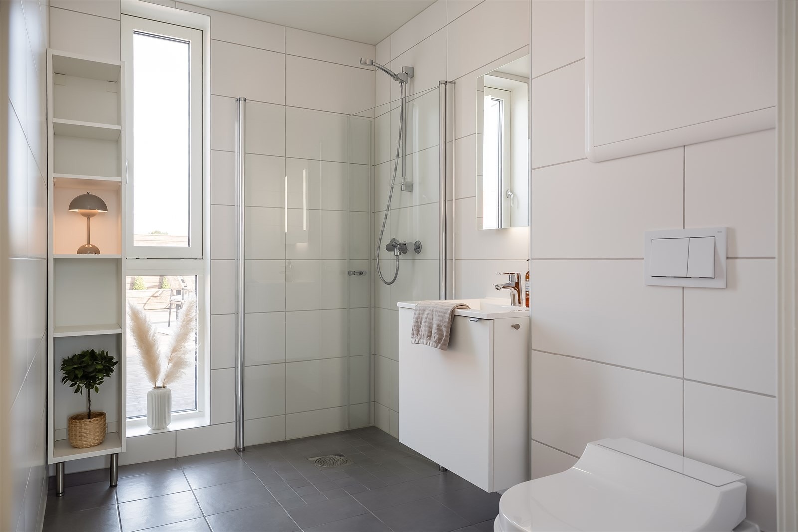 Flott gjestebad på 5 m² med egen dusj og spyletoalett fra Geberit. Rommets bredde gir muligheter for å etablere badekar om ønskelig. Badet er vurdert til TG0 av takstmann. Galleribilde