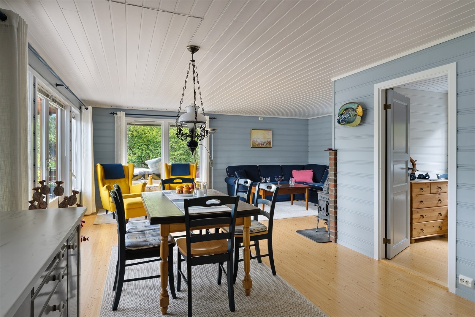 Den åpne løsningen mellom stuen og kjøkkenet skaper en sosial og hjemmekoselig atmosfære, perfekt til sosiale sammenkomster. Galleribilde