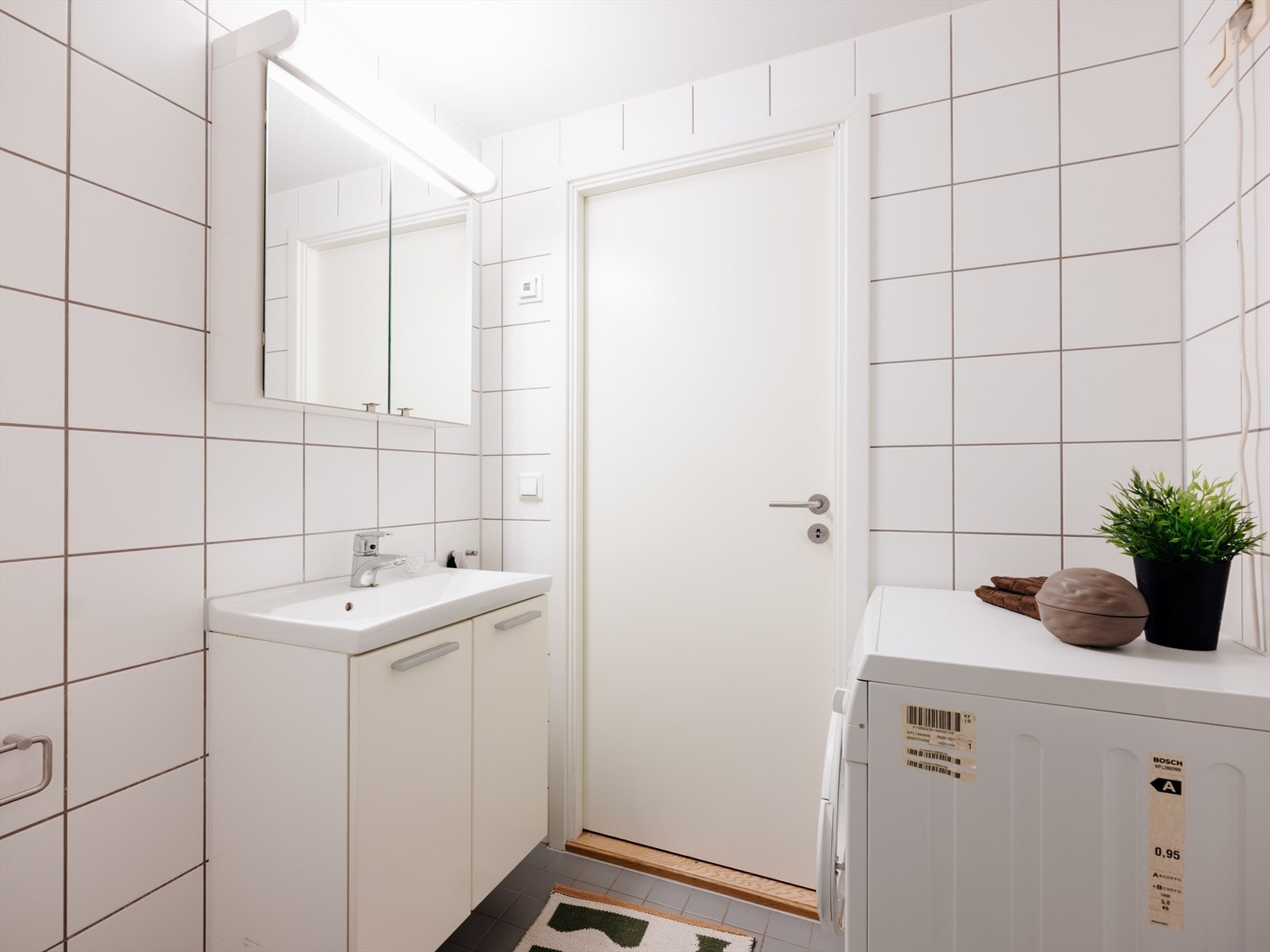 Badet er innredet med servant i skapseksjon, speilskap og veggmontert toalett. Galleribilde