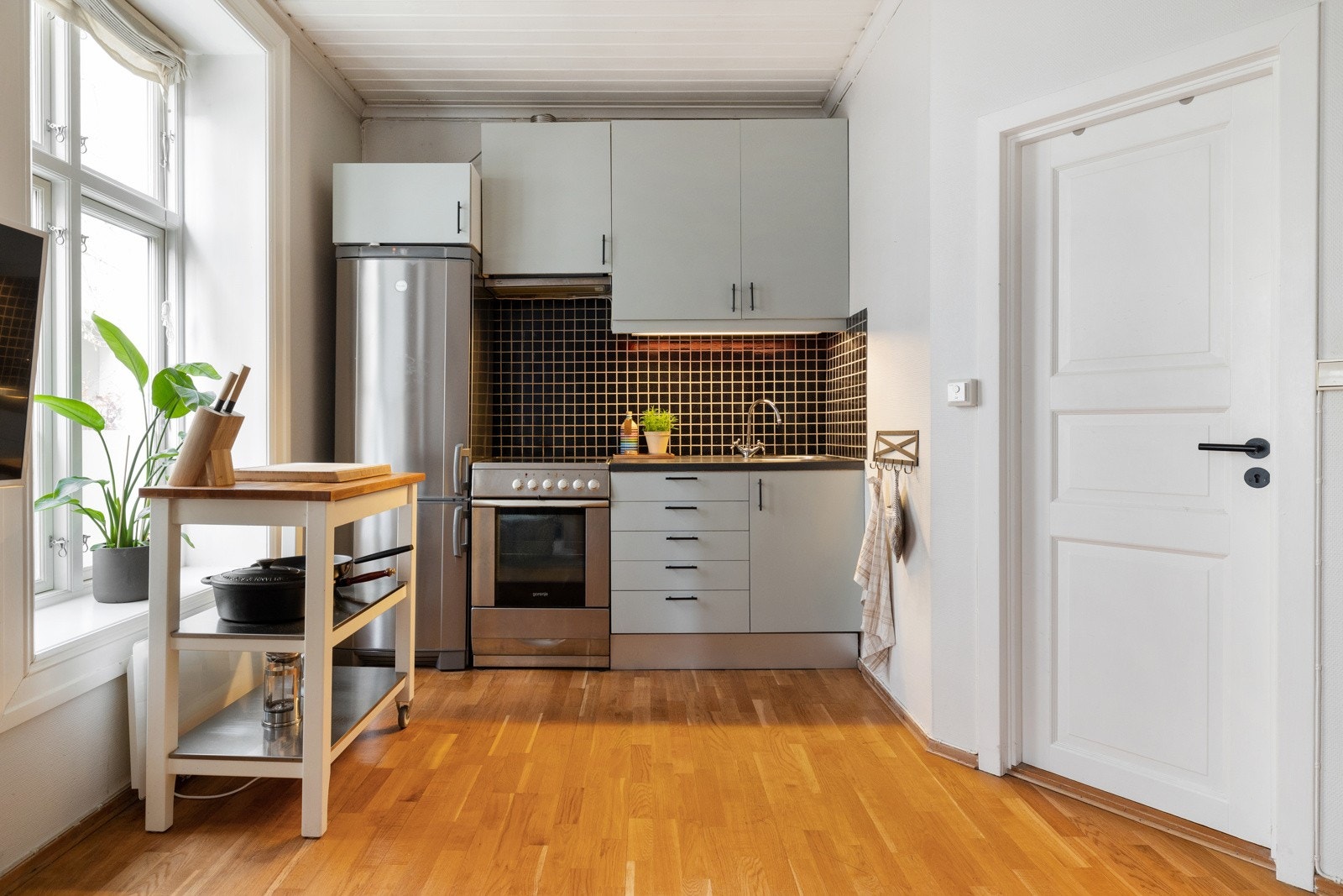 Kjøkkeninnredningen har glatte fronter og laminat benkeplate Galleribilde