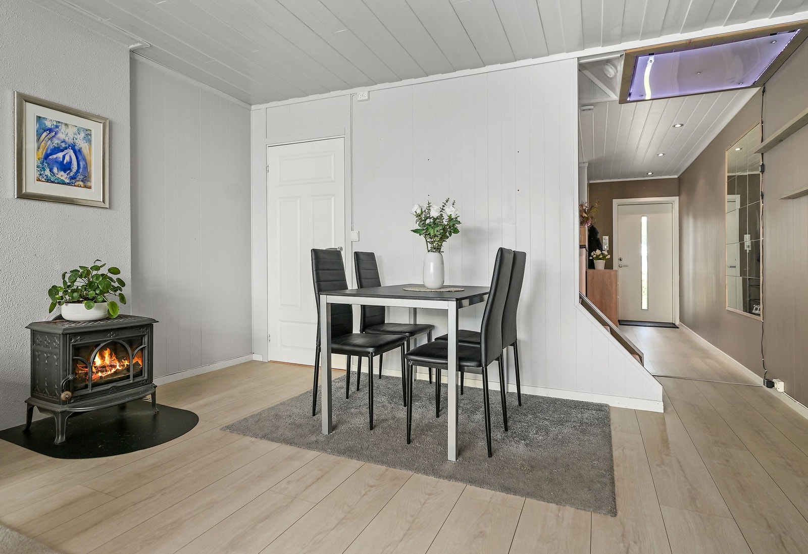 Sentralt i rommet er det vedovn som varmer godt, og gir mye kos og hygge på mørke høst- og vinterkvelder. Galleribilde