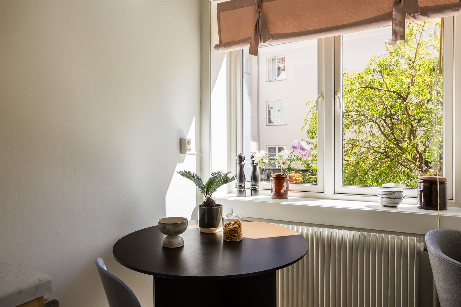 Treet utenfor kjøkkenvinduet blir knall rosa i slutten av april, og grønt resten av sommeren. Her kan du nyte fredfulle stunder mot stille bakgård. Galleribilde